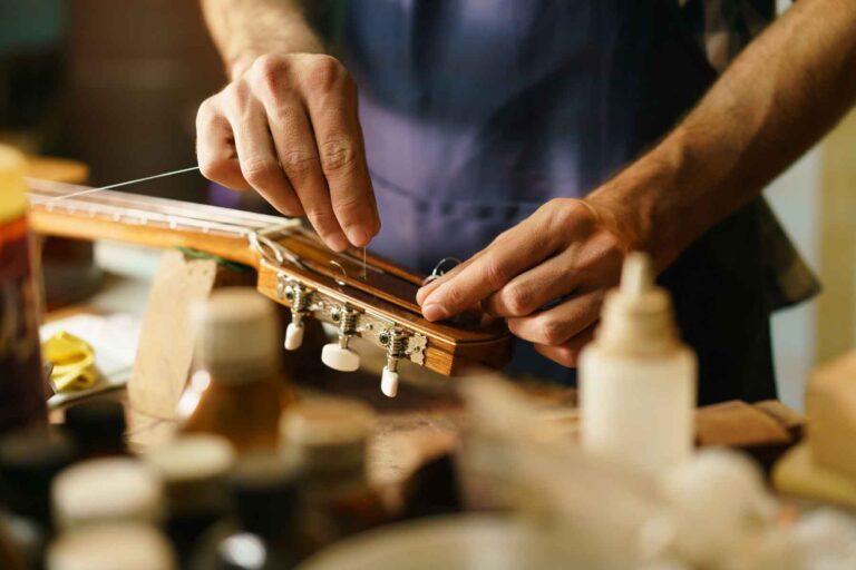 artisan-lute-maker-fixing-guitar-replacing-cords-768x512